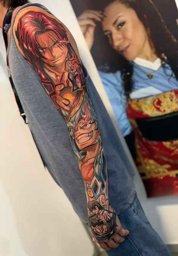 Brazo entero a color con personajes de One Piece: Shanks arriba, con su pelo rojo, y los demás hasta la muñeca.