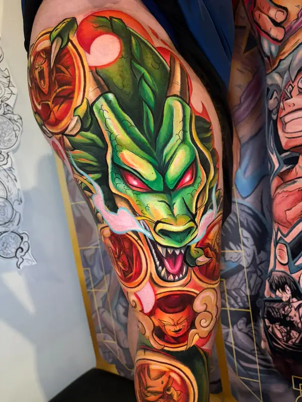 Shenron, el dragón de Dragon Ball, en verde con los ojos rojos y las bolas de dragón alrededor, a color en la pierna.