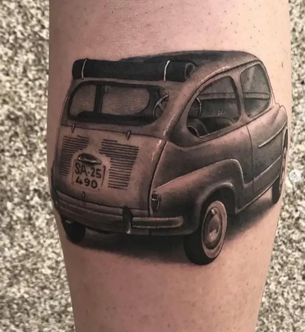 Un Seat 600 con su matrícula antigua, en negro y grises en la pierna.