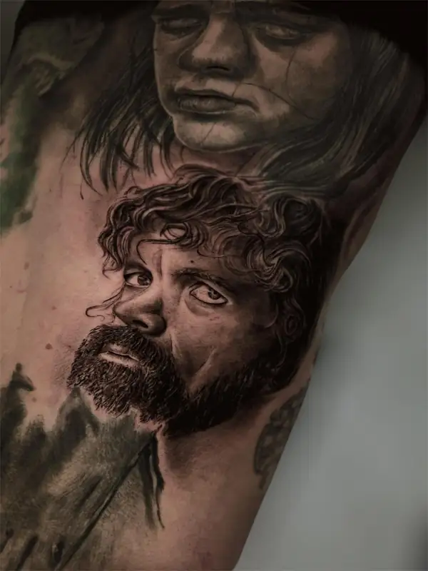 Tyrion, de Juego de tronos, en negro y grises en el brazo, con otro rostro encima.