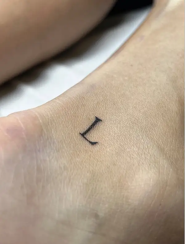 Una letra «L» pequeña en el pie.