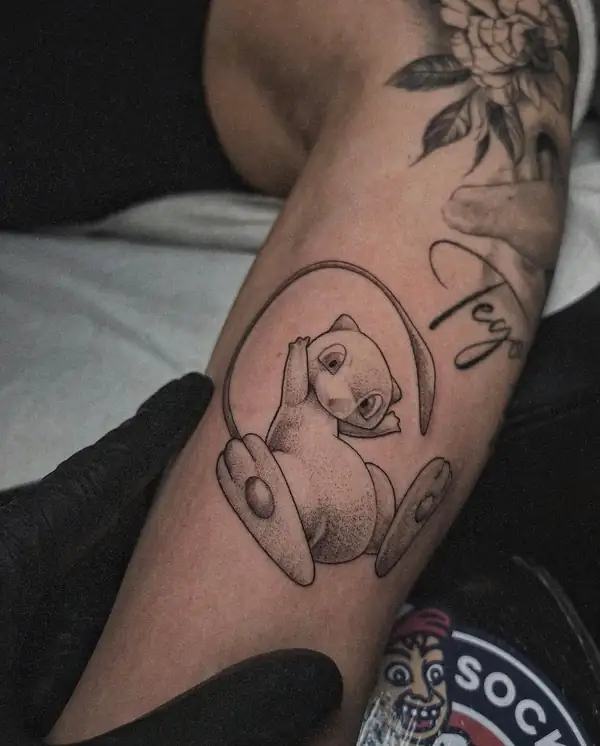 Un osito sentado dentro de un aro, en puntillismo en el antebrazo.