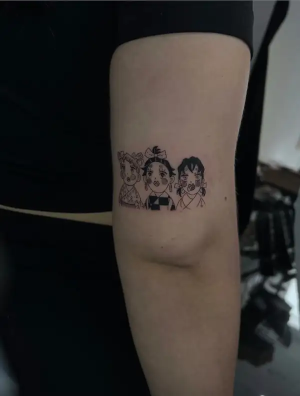 Tres personajes de anime en pequeño, en línea fina y negro, en el brazo.