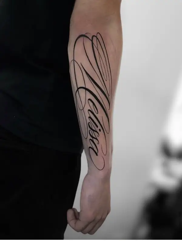 Un nombre en letra caligráfica grande a lo largo del antebrazo.