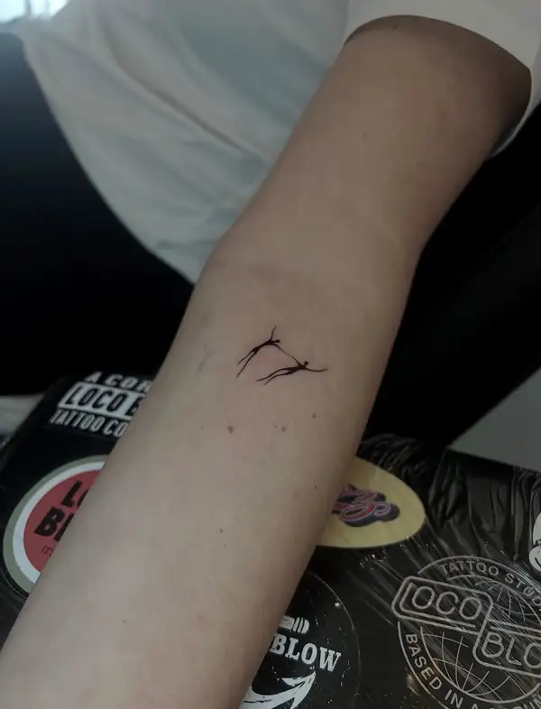 Unos trazos finos, como un pájaro en vuelo, en el antebrazo.