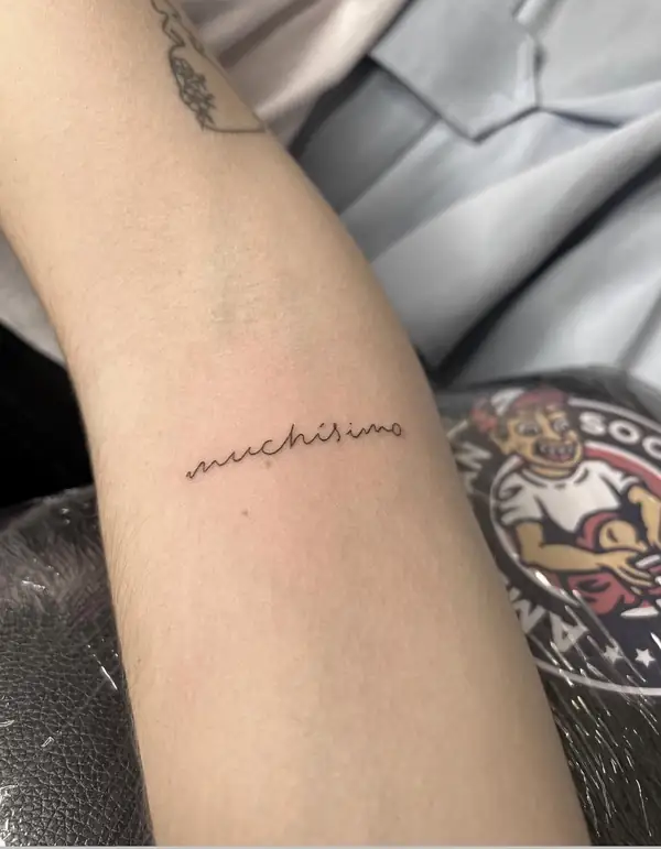 La palabra «muchísimo» en letra cursiva fina en el antebrazo.