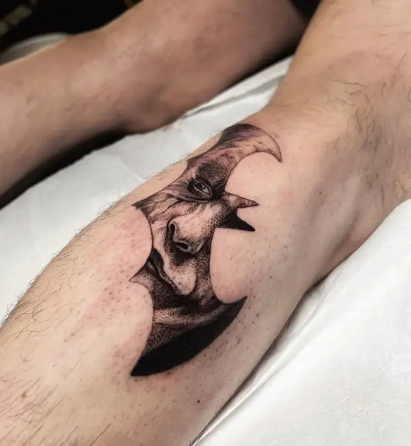 Un rostro dentro de una luna creciente, en puntillismo en la pierna.