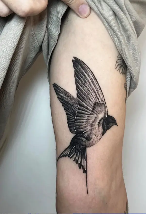 Una golondrina en vuelo en puntillismo, en el brazo.