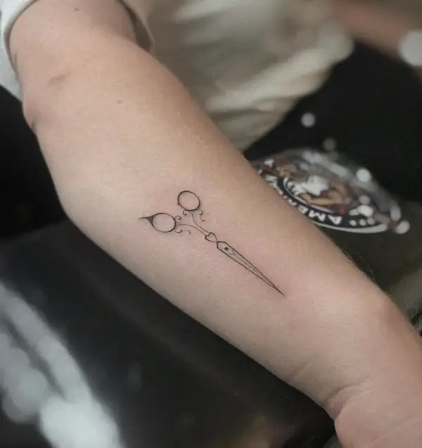 Unas tijeras en línea fina en el antebrazo.