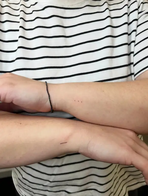 Dos muñecas, cada una con un tatuaje mínimo a juego.