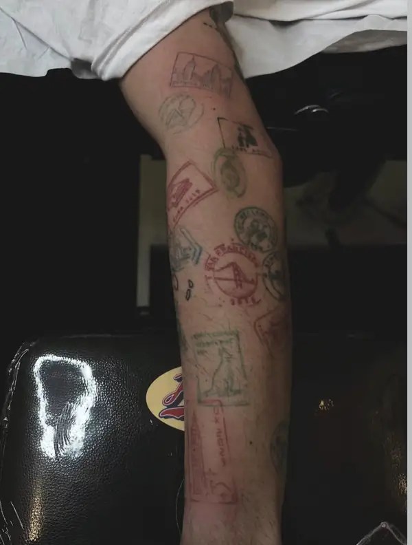 Sellos de correos de viaje, a color, uno junto a otro por todo el antebrazo.