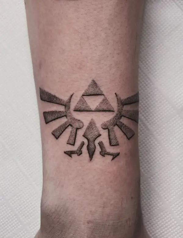 La Trifuerza de Zelda con sus alas, en puntillismo en la pierna.
