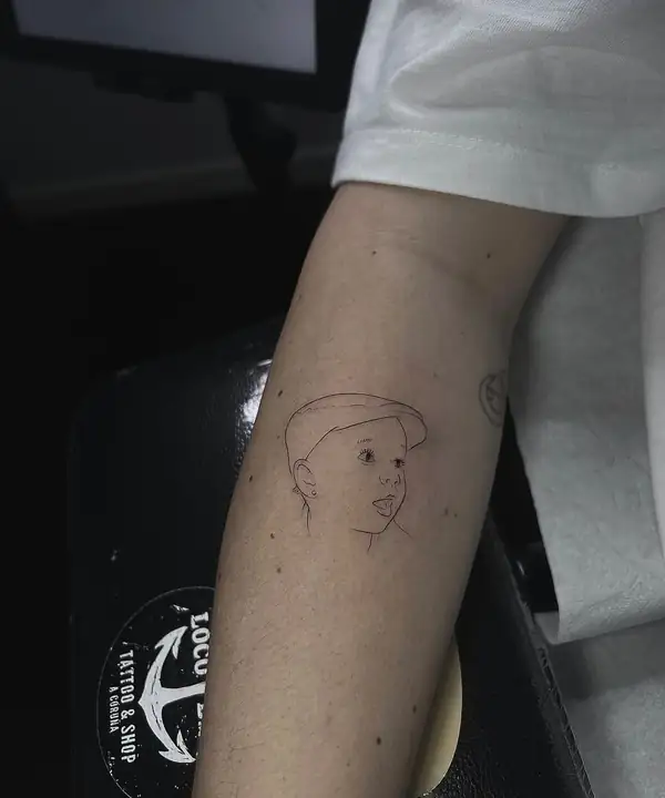 Retrato de un niño con gorra, en línea fina en el antebrazo.