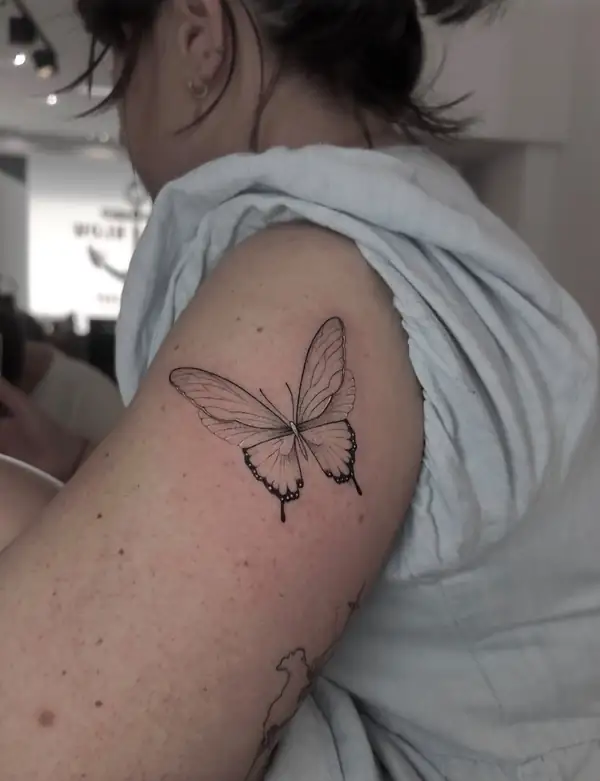 Una mariposa en línea fina en la parte de atrás del brazo.