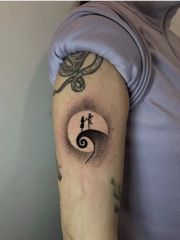 Jack y Sally sobre la colina en espiral, recortados contra la luna, en puntillismo en el brazo.