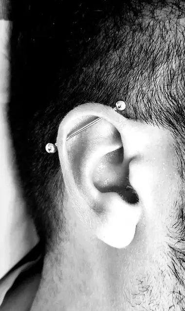 Industrial: una barra recta que cruza la parte de arriba de la oreja, en blanco y negro.